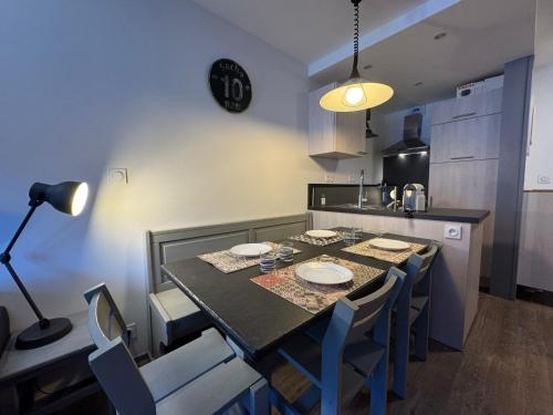 une cuisine avec une table avec des chaises et une salle à manger dans l'établissement HB 3031 - Tignes Val Claret Hameau du Borsat, à Tignes