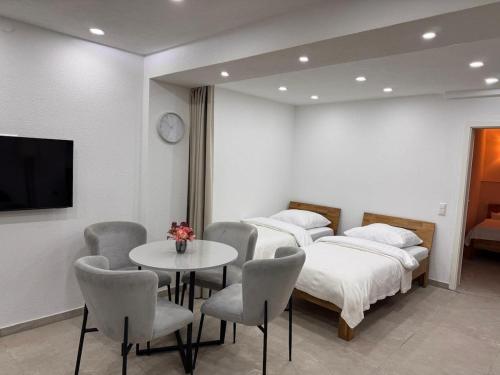 a room with two beds and a table and chairs at Traumhaft moderne Ferienwohnung in 78554Aldingen in Aldingen