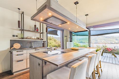 une cuisine avec une grande table et des chaises en bois dans l'établissement Villa MARE- Pieds dans l'eau, 3 chambres, vue mer, à Pietrosella