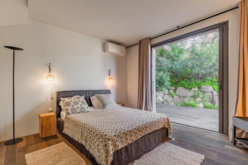 une chambre avec un lit et une grande fenêtre dans l'établissement Villa MARE- Pieds dans l'eau, 3 chambres, vue mer, à Pietrosella