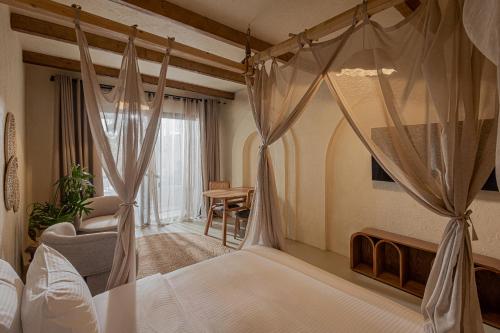 a bedroom with a canopy bed and a living room at Serab Residencia, Boutique Hotel & Resort in Al Kaslīk