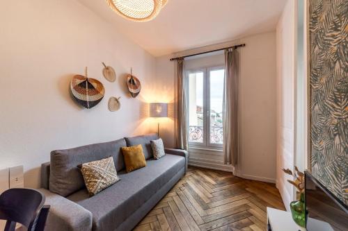 un salon avec un canapé et une fenêtre dans l'établissement Le Tolstoï, à Villeurbanne