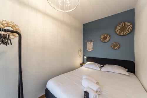 - une chambre dotée d'un lit avec un mur bleu dans l'établissement Le Tolstoï, à Villeurbanne