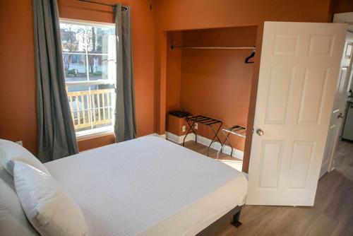 a bedroom with a white bed and a window at StayAE Downtown - 1BR Apartment, Ground Floor in Baton Rouge