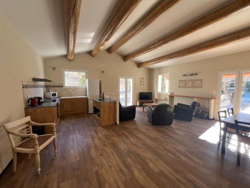 a large living room with a table and a kitchen at Villas de La Ferme Du Gros Noyer in Malaucène