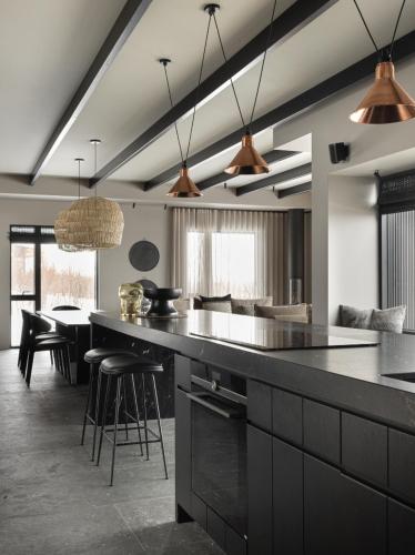a kitchen with a large counter and a dining room at Svart Lodge in Akureyri