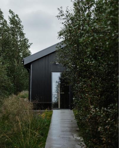 a black building with a door and a walkway at Svart Lodge in Akureyri