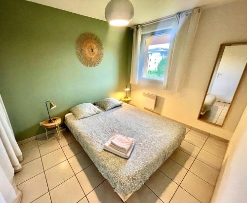 een slaapkamer met een bed en een spiegel aan de muur bij " Côté Parc " Cité de l'espace - Entrée autonome in Toulouse