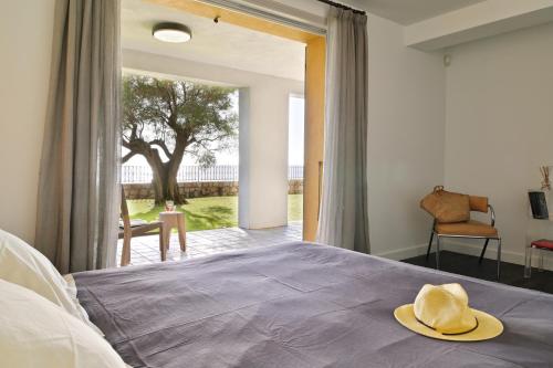 une chambre avec un lit avec un chapeau dessus dans l'établissement VILLA DOLCE VITA- 6 chambres, pieds dans l'eau, vue mer, piscine,, à Ajaccio