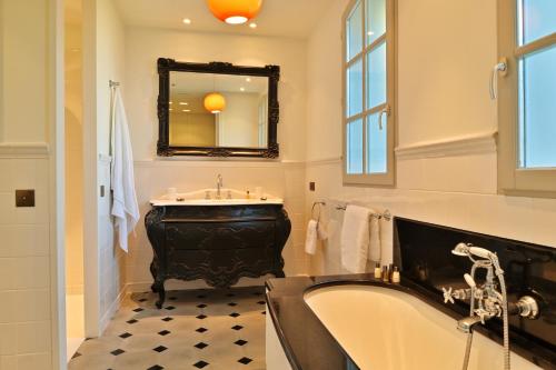 une salle de bain avec une baignoire, un lavabo et un miroir dans l'établissement VILLA DOLCE VITA- 6 chambres, pieds dans l'eau, vue mer, piscine,, à Ajaccio