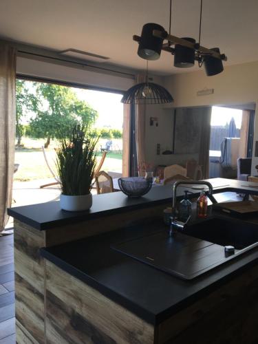 d'une cuisine avec un comptoir, un évier et une fenêtre. dans l'établissement La Longère de Chillac campagne chic jacuzzi, à Morizès