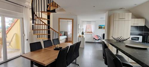 une cuisine et une salle à manger avec une table et des chaises en bois dans l'établissement Au coeur des vignes, à Kintzheim
