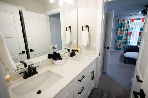 a white bathroom with a sink and a mirror at Retro Rose Retreat-Rose District in Broken Arrow