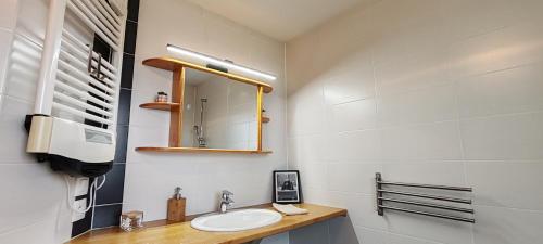 a bathroom with a sink and a mirror at Au coeur des vignes in Kintzheim