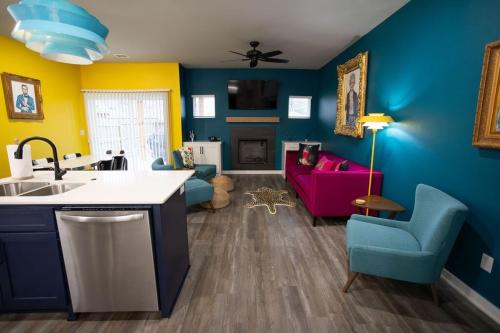 a kitchen with blue and yellow walls and a living room at Retro Rose Retreat-Rose District in Broken Arrow