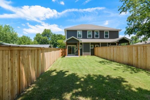 a wooden fence in front of a house at Retro Rose Retreat-Rose District in Broken Arrow
