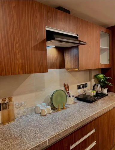 a kitchen with wooden cabinets and a green plate on a counter at Liv box hotel in Rājpur