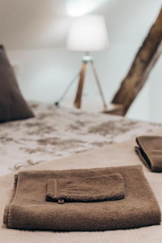 a brown blanket on a bed with a lamp at Ferme des Petites Oreilles 4 étoiles in Montignac