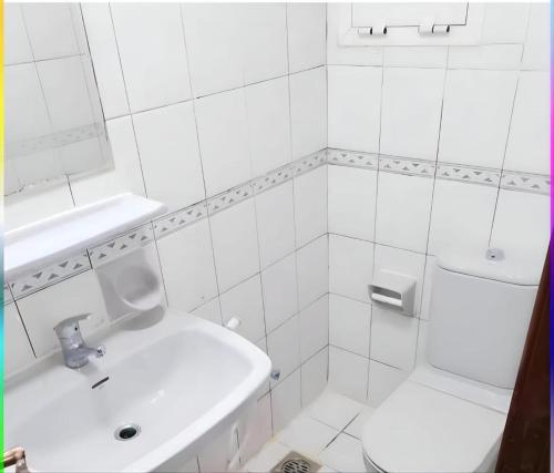 a white bathroom with a sink and a toilet at New Phenomenal Room with Sea View in Abu Dhabi