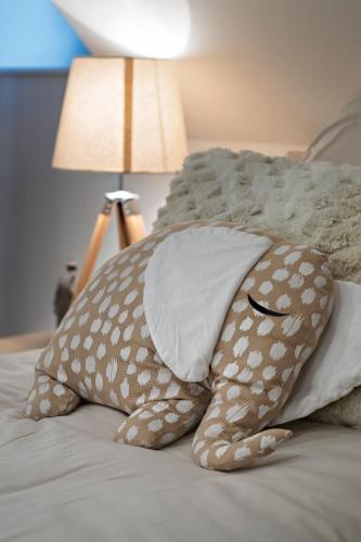 a bed with pillows and a lamp on it at Ferme des Petites Oreilles 4 étoiles in Montignac