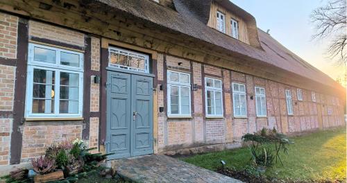un edificio in mattoni con una porta e finestre blu di Hotel Landhaus Plus Lüneburg a Lüneburg