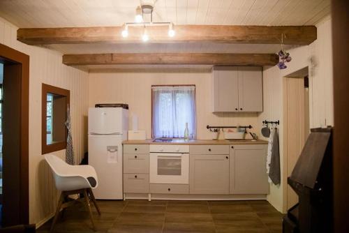 a kitchen with a white refrigerator and a chair at Chata u starkého in Kováčová
