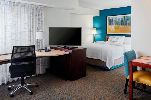 a hotel room with a bed and a desk with a computer at Residence Inn Saint Louis Airport / Earth City in Earth City