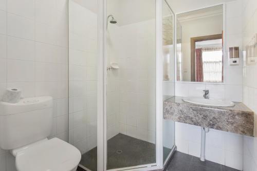 a bathroom with a shower and a toilet and a sink at The Emperors Crown Hostel in Perth