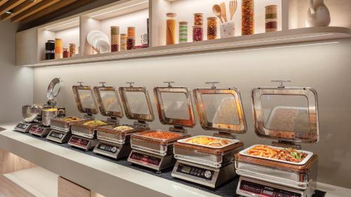 a row of trays of food on a shelf at Holiday Inn Express Singapore Orchard Road by IHG in Singapore