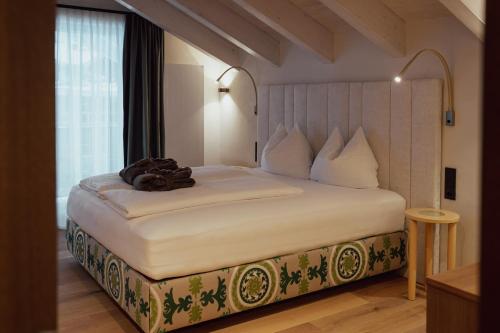 a bedroom with a large bed with a teddy bear on it at Hotel Auszeit in Pertisau