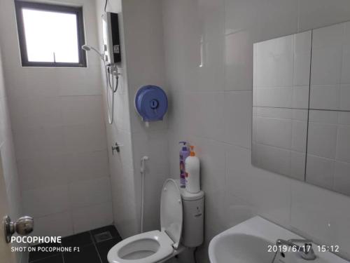 a white bathroom with a toilet and a window at Vista Alam S Studio in Shah Alam