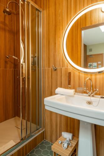 une salle de bain avec un lavabo et une douche dans l'établissement Hôtel d'Angleterre, à Versailles