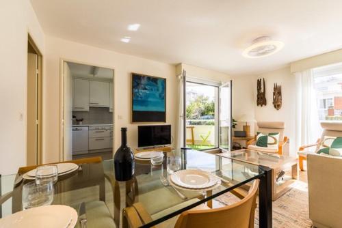 une salle à manger avec une table en verre et une cuisine dans l'établissement SABLE - Proximité Grande Plage, à Biarritz