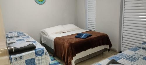 a bedroom with a bed with a blanket on it at Pousada Canto dos Passaros in Chapada dos Guimarães