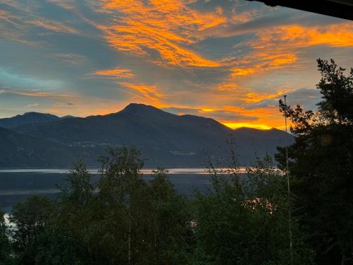 a sunset over a body of water with mountains at FjordView in Stranda