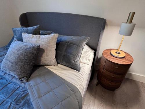 a bed with pillows and a table with a lamp at Wildrose Villas in Brownsville