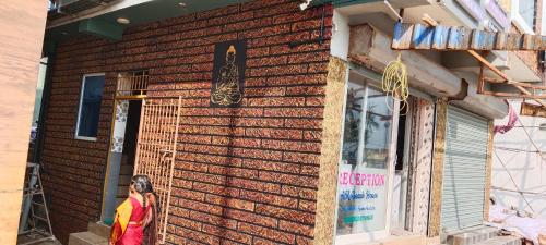 a woman standing outside of a brick building at AK Beach House in Velankanni