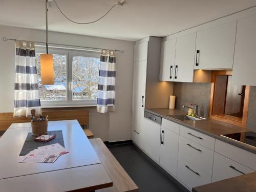 a kitchen with white cabinets and a table and a window at Haus Angelika in Vandans