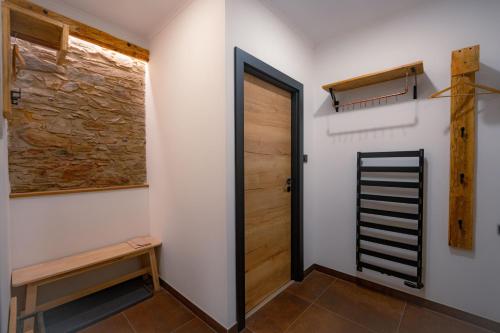 a room with a door and a bench and a wall at Pechblend & Silberstein in Jáchymov