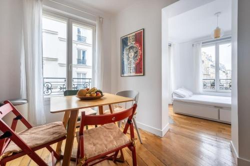 une salle à manger avec une table et des chaises et une chambre dans l'établissement Cosy Apartment with 270 degrees view on Paris streets, à Paris
