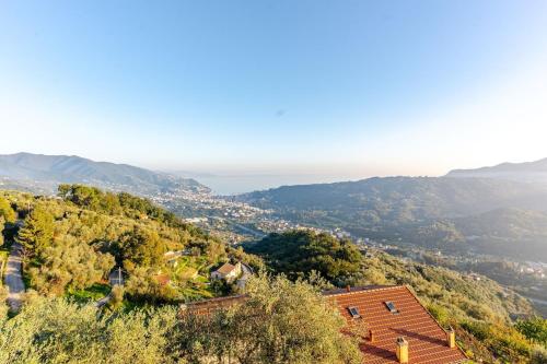 a house on a hill with the ocean in the background at Sea-View Retreat - Pool, Tavern, Fireplace in Rapallo