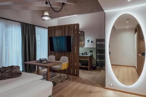 a room with a bed and a table and a mirror at Hotel Auszeit in Pertisau