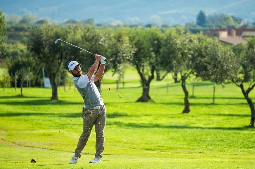 a man swinging a golf club in a field at Pescara INN Via Sulmona 17 in Pescara