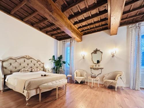 una camera da letto con un letto, due sedie e uno specchio di Trevi Fountain Elegant Apartment a Roma