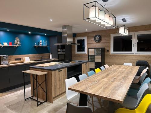 une cuisine avec une grande table et des chaises en bois dans l'établissement Chalet PLUME D'EAU - jacuzzi, piscine et pétanque, à Gerbépal