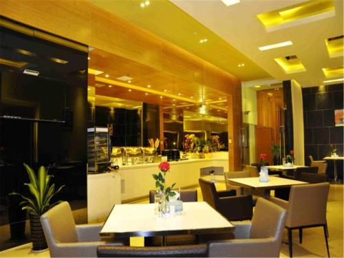 a restaurant with tables and chairs and a bar at Jinjiang Inn Xiamen North Railway Station Jiageng Sports Stadium in Xiamen
