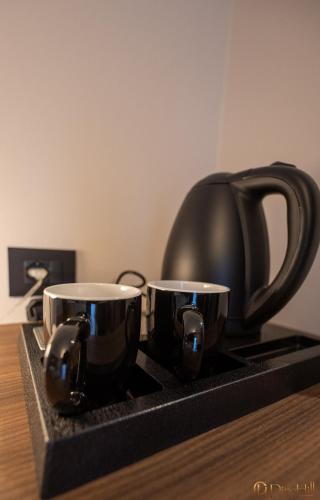 two coffee cups sitting on a stove with a tea kettle at PineHill Hotel, Restaurant , Pool & Spa - RAZEM in Razëm