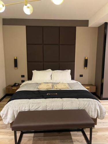 a bedroom with a large bed with a large headboard at PineHill Hotel, Restaurant , Pool & Spa - RAZEM in Razëm