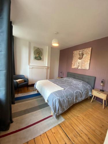 une chambre avec un lit et une chaise dedans dans l'établissement Au logis de Abi, à Cherbourg en Cotentin
