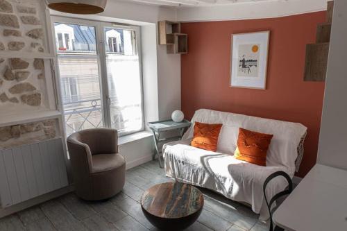 a living room with a couch and a chair at Cozy apartment in Le Marais in Paris